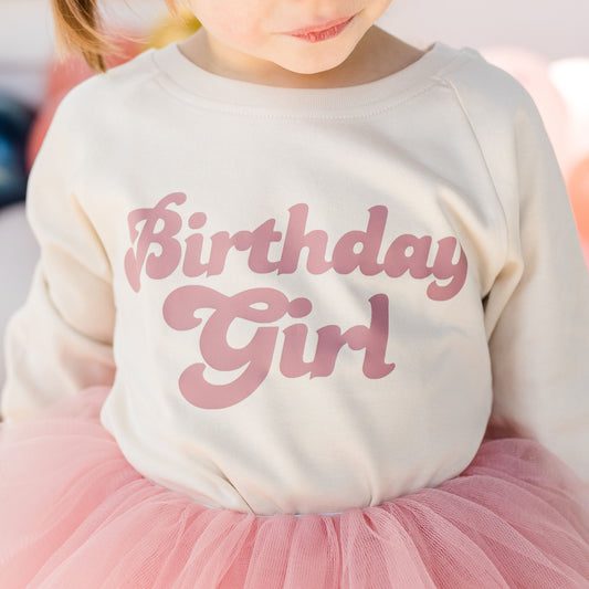 Girl in cream top with pink birthday girl printed with mauve pink tutu skirt