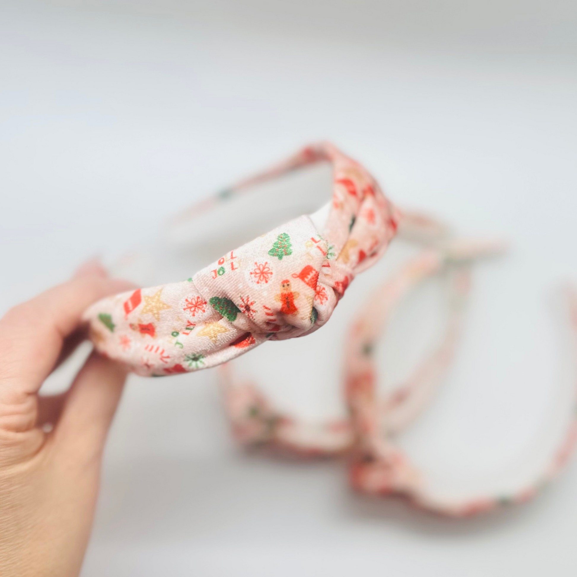 Pink velvet headband with gingerbread men, candy canes, trees, and snowflakes pattern