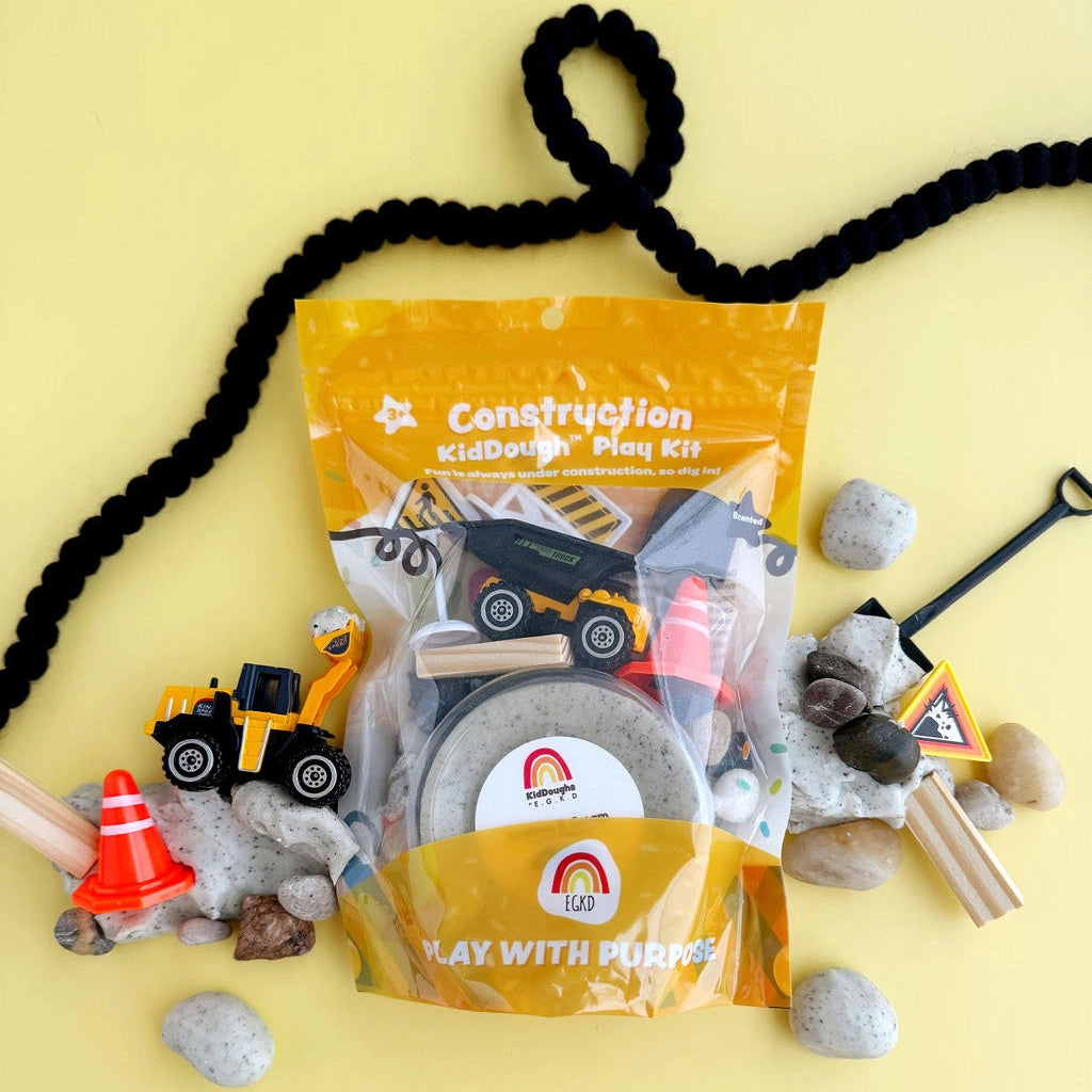 Construction play kit with toys and accessories on a yellow background
