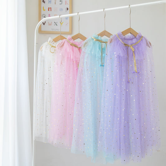 Tulle stary Capes for kids dress up on wood hangers lined up on white clothing bar. 