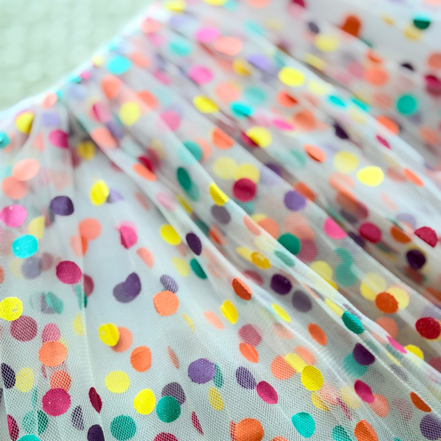 Multicolored polka dot fabric with a light background