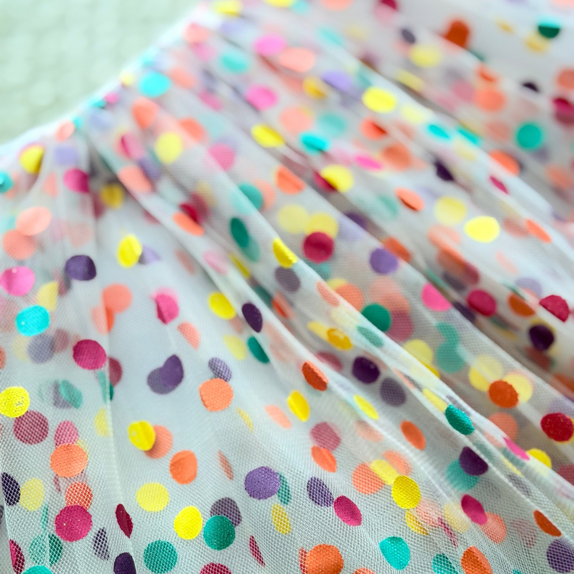 Multicolored polka dot fabric with a light background