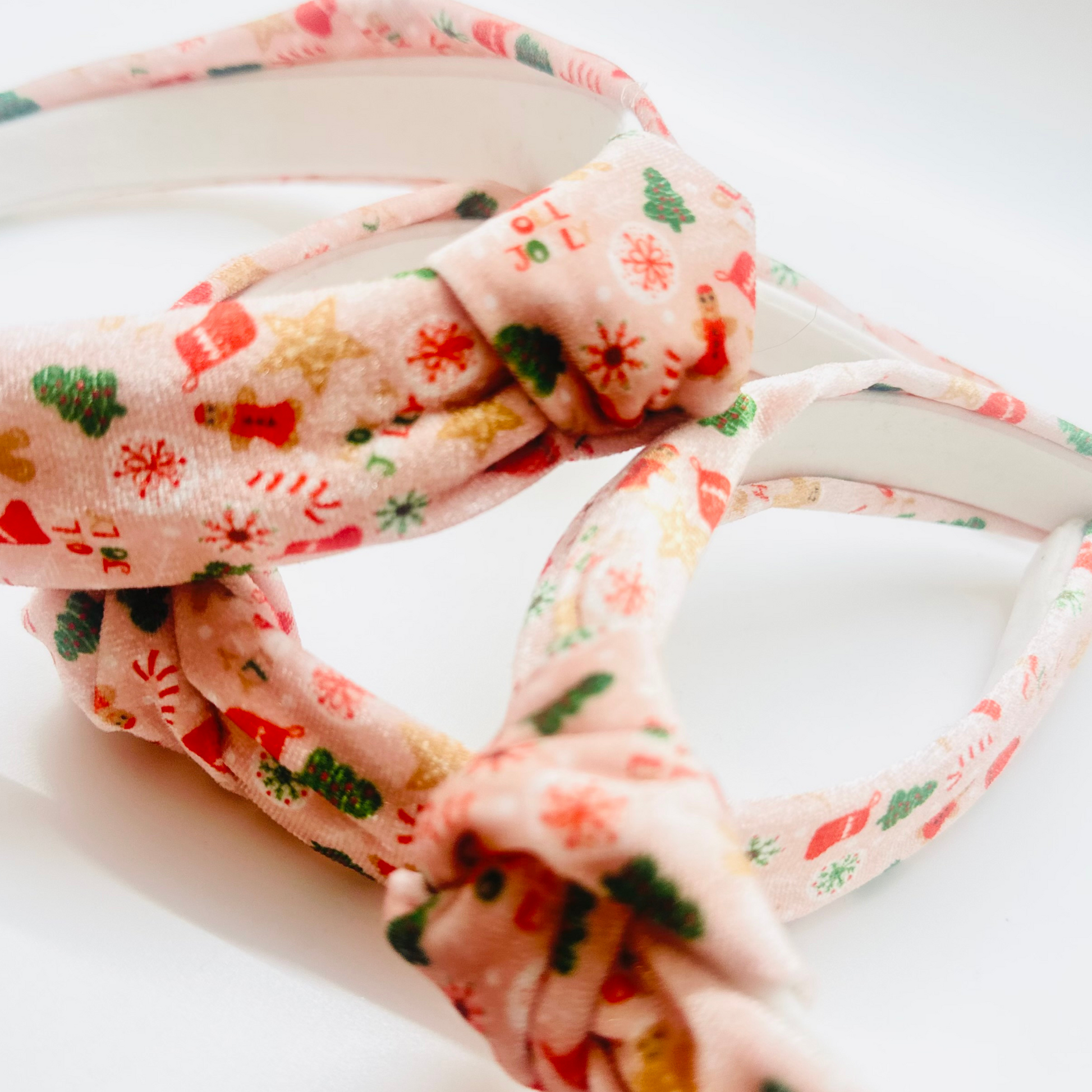 Pink velvet headband with gingerbread men, candy canes, trees, and snowflakes pattern