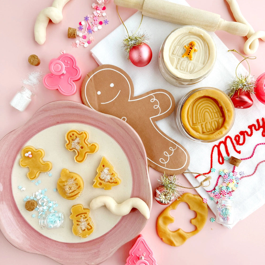 Decorative Christmas cookies with cookie cutters on a pink background