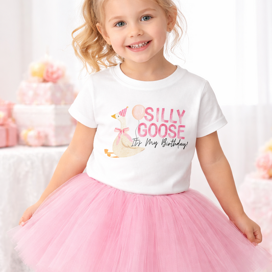Little girl wearing a graphic shirt with a goose in a party hat holding a balloon with the saying Silly Goose It's My Birthday on it. Paired with The Glam Goats light pink full layered tutu for toddler or little girls. 